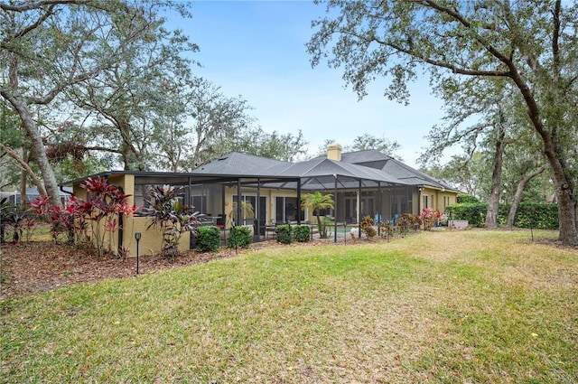 back of house featuring a yard and a lanai