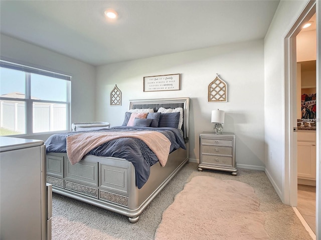 bedroom with light carpet and baseboards