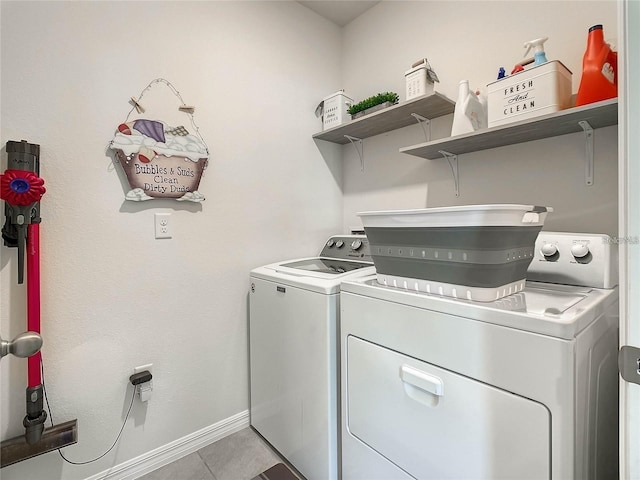 laundry area featuring baseboards, light tile patterned flooring, laundry area, and washer and clothes dryer