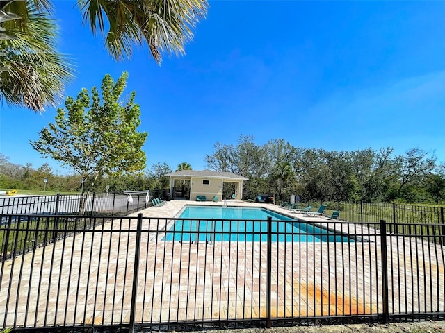 pool with a patio and fence