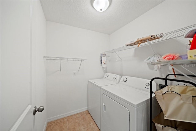 washroom featuring sink, a textured ceiling, washing machine and clothes dryer, and light tile patterned flooring