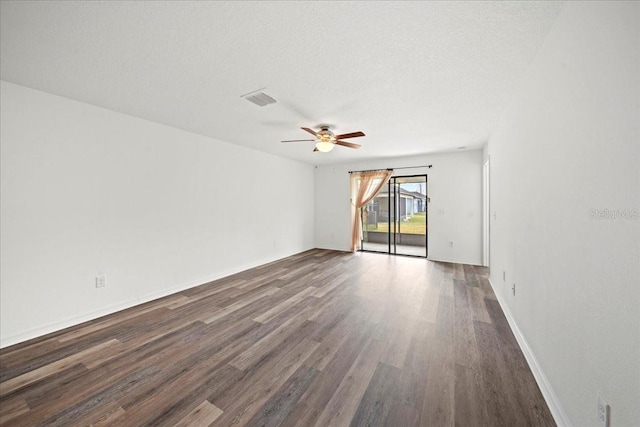 spare room with ceiling fan, dark wood-type flooring, and a textured ceiling