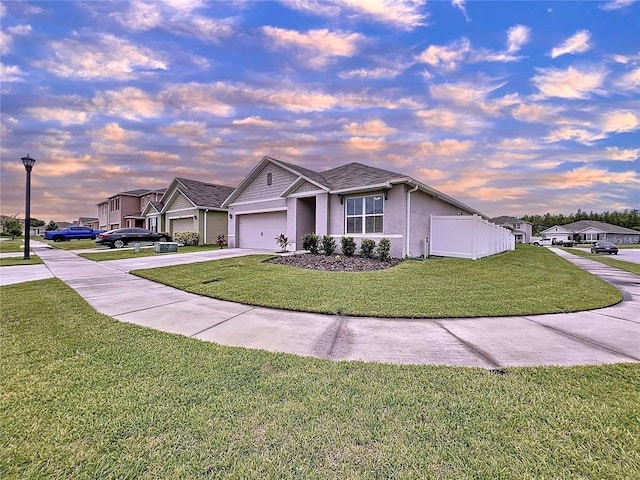 view of front of home with a garage and a yard