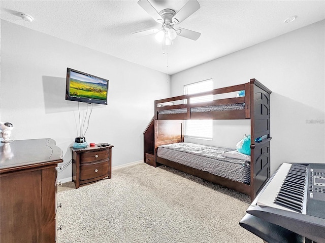 bedroom with ceiling fan, carpet floors, and a textured ceiling