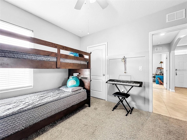 tiled bedroom featuring a textured ceiling and ceiling fan