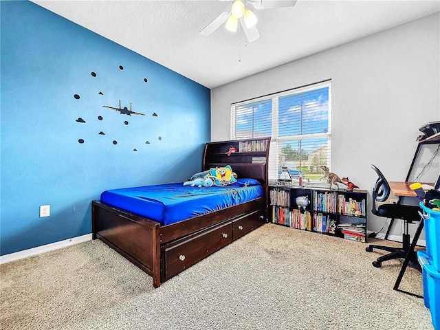 carpeted bedroom featuring ceiling fan and a textured ceiling