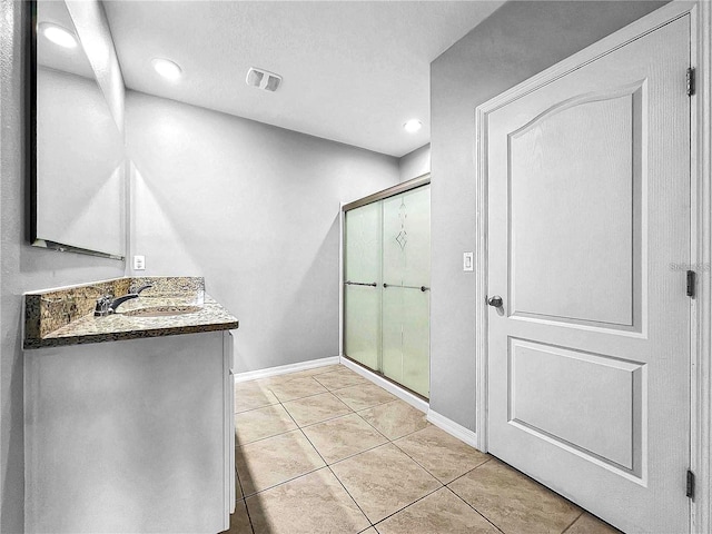 bathroom with tile patterned flooring, vanity, and a shower with shower door