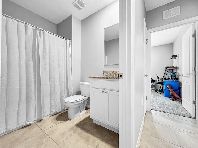 bathroom featuring vanity, tile patterned floors, and toilet