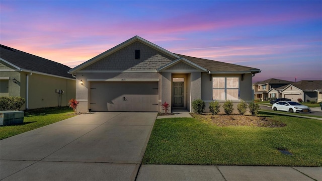 view of front facade featuring a garage, driveway, a lawn, and stucco siding