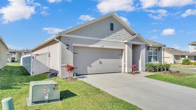 view of front of property featuring driveway, a residential view, an attached garage, a front lawn, and stucco siding