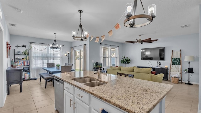 kitchen featuring visible vents, dishwasher, a kitchen island with sink, white cabinetry, and a sink