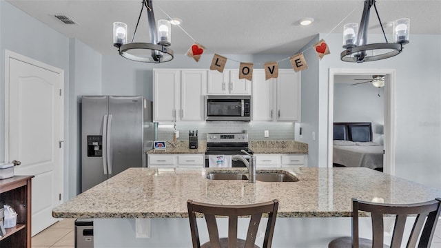 kitchen featuring white cabinets, decorative backsplash, stainless steel appliances, and a sink