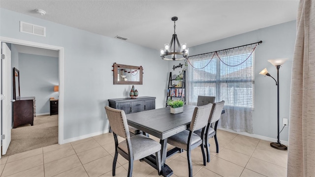 dining area with light tile patterned flooring, visible vents, and a notable chandelier