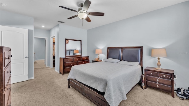 bedroom with a ceiling fan, visible vents, light carpet, and baseboards