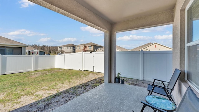 view of yard featuring a patio area, a fenced backyard, and a residential view