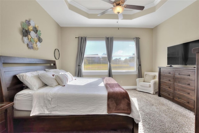 carpeted bedroom featuring ceiling fan, ornamental molding, and a raised ceiling