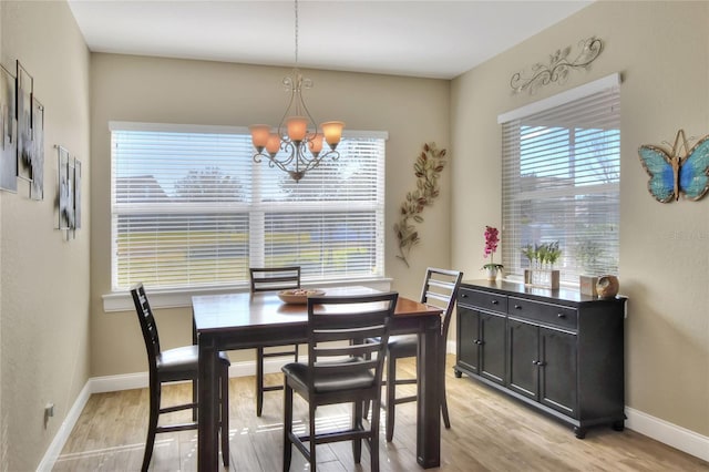 dining room with an inviting chandelier and light hardwood / wood-style flooring