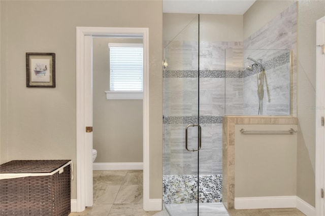 bathroom featuring toilet and an enclosed shower