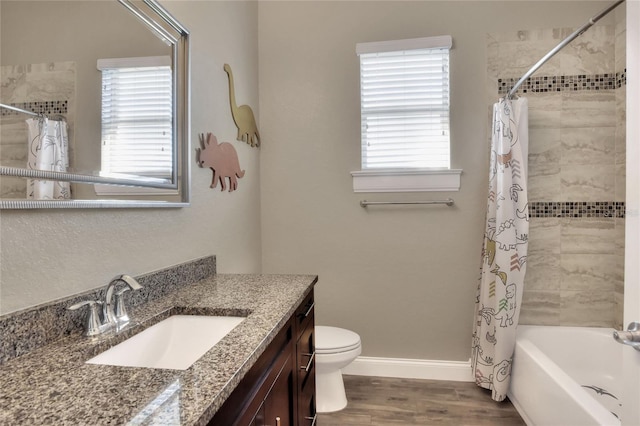 full bathroom featuring vanity, hardwood / wood-style floors, shower / bathtub combination with curtain, and toilet