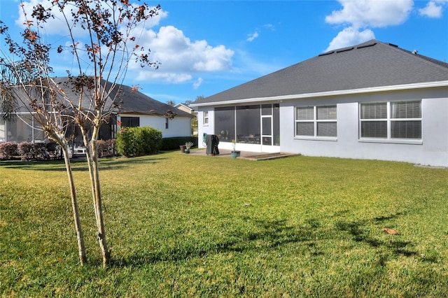 rear view of property with a yard and a sunroom