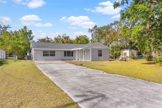 ranch-style house featuring a front lawn and a storage unit