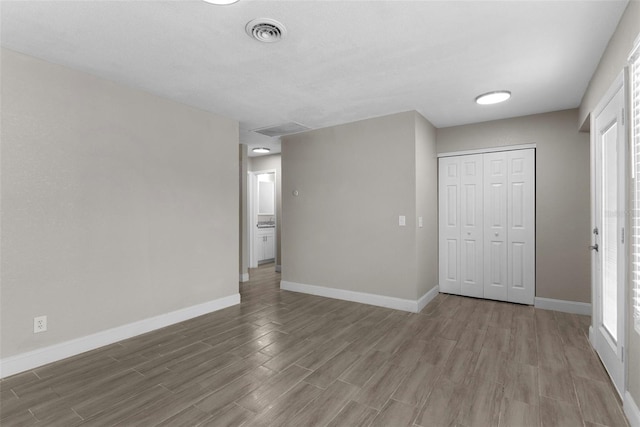 unfurnished bedroom with hardwood / wood-style flooring and a closet