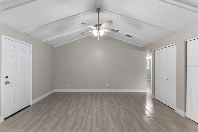 unfurnished bedroom with vaulted ceiling with beams, multiple closets, ceiling fan, and light wood-type flooring