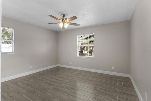 empty room with dark hardwood / wood-style flooring, a textured ceiling, and ceiling fan