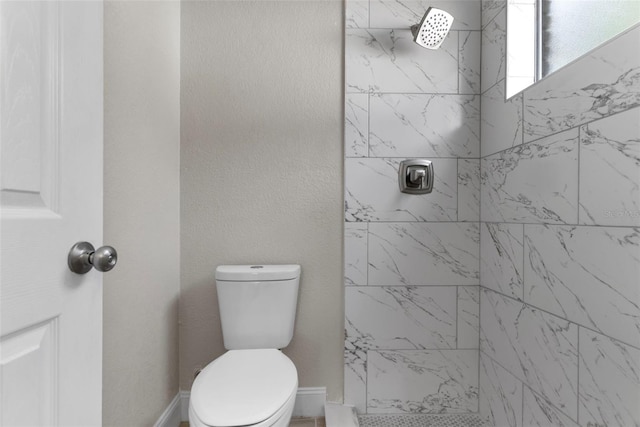 bathroom featuring a tile shower and toilet