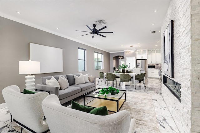 living room featuring ornamental molding and ceiling fan