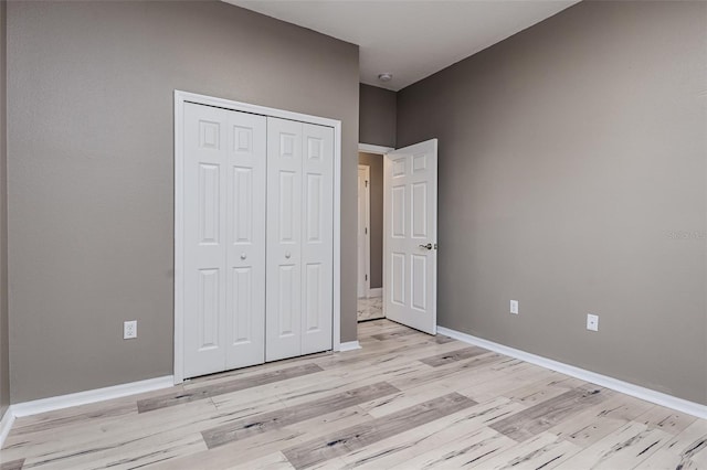 unfurnished bedroom featuring light hardwood / wood-style floors and a closet