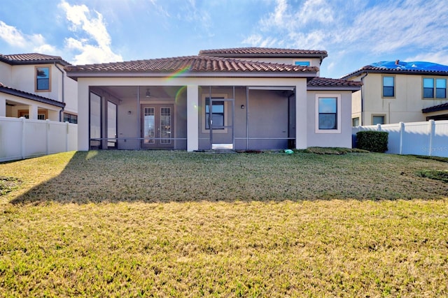 back of house featuring a sunroom and a lawn