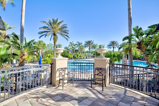 view of patio / terrace with a water view and a community pool