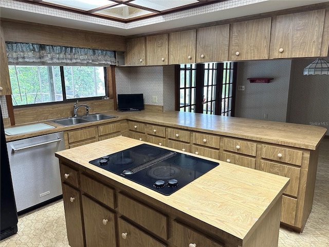 kitchen featuring stainless steel dishwasher, black electric stovetop, sink, and a kitchen island