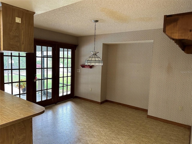 unfurnished dining area featuring a textured ceiling