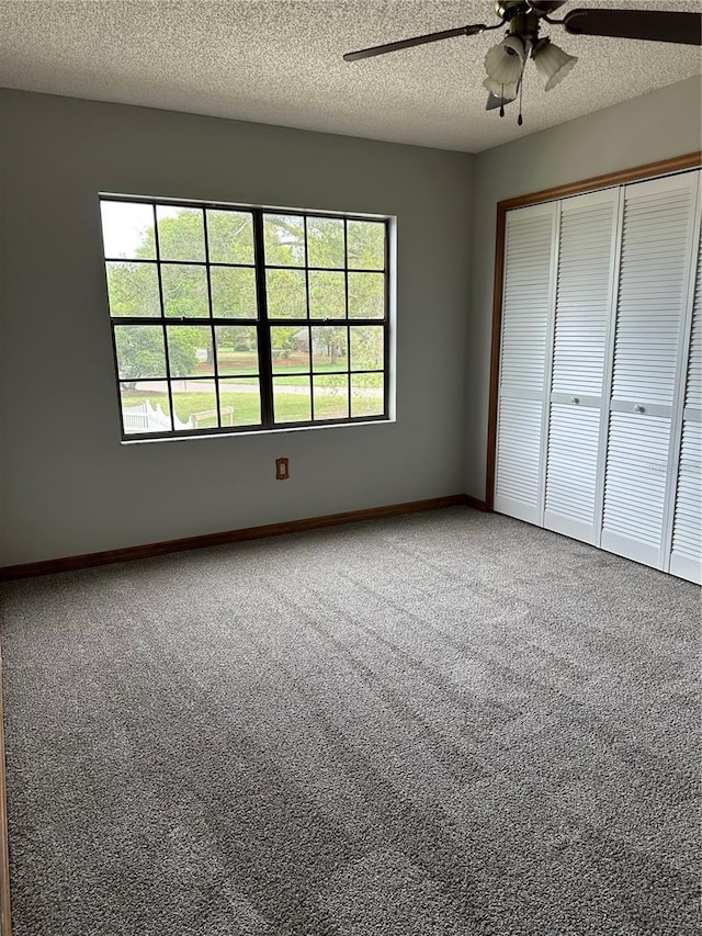 unfurnished bedroom featuring ceiling fan, carpet, a textured ceiling, and a closet