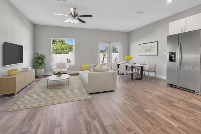 living room with light hardwood / wood-style flooring and ceiling fan