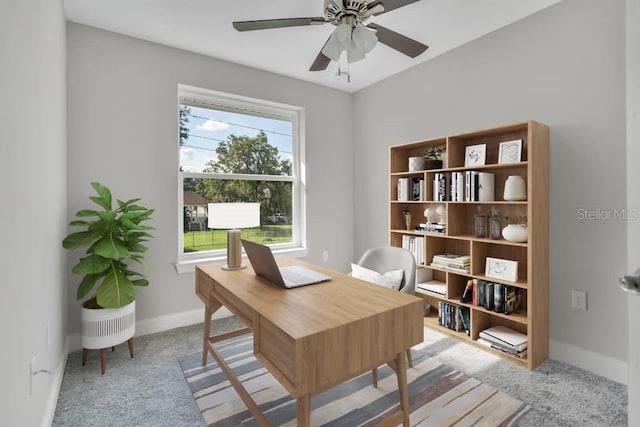 carpeted home office featuring ceiling fan