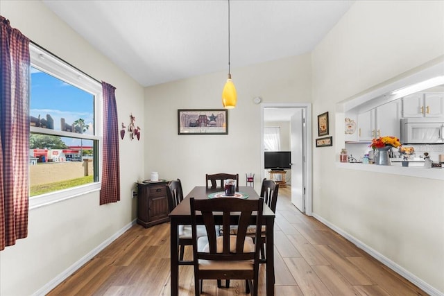 dining area featuring lofted ceiling and wood-type flooring