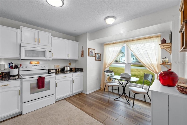 kitchen with white appliances, light hardwood / wood-style floors, and white cabinets