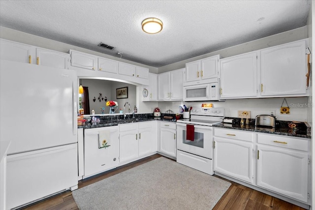 kitchen with sink, white appliances, dark wood-type flooring, a textured ceiling, and white cabinets