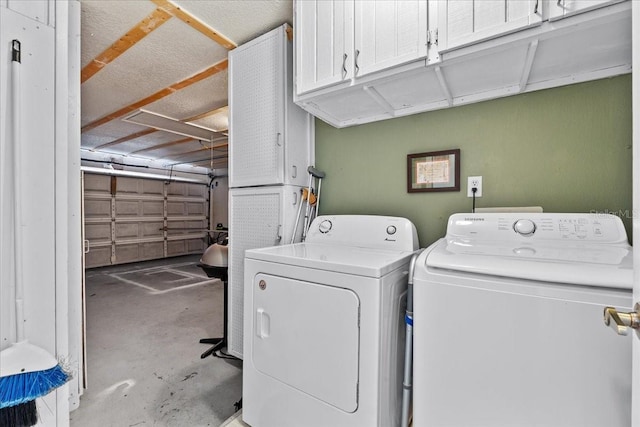 laundry room with cabinets and washing machine and clothes dryer