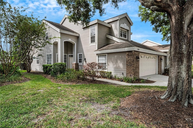 traditional-style home with driveway, a front lawn, an attached garage, and brick siding