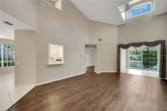 unfurnished living room featuring plenty of natural light, ceiling fan, and light wood finished floors