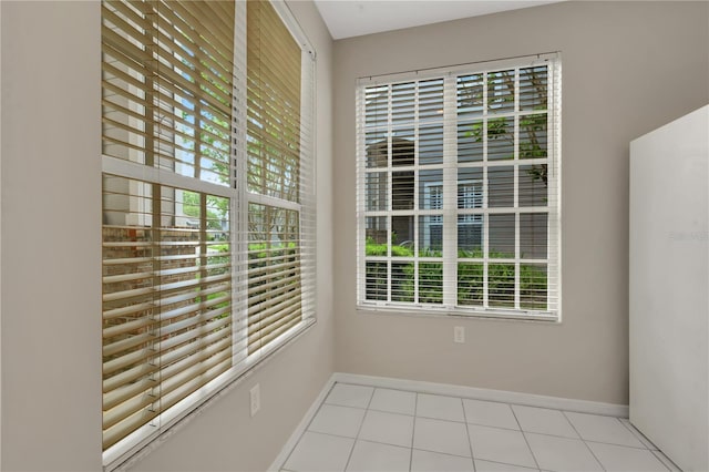 unfurnished room featuring light tile patterned flooring and baseboards