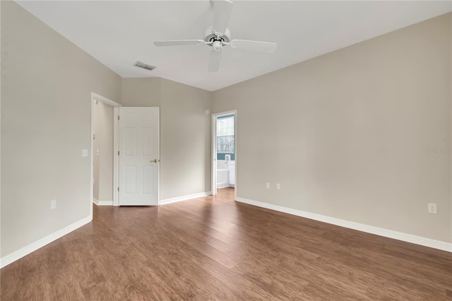 empty room featuring ceiling fan, dark wood-type flooring, visible vents, and baseboards