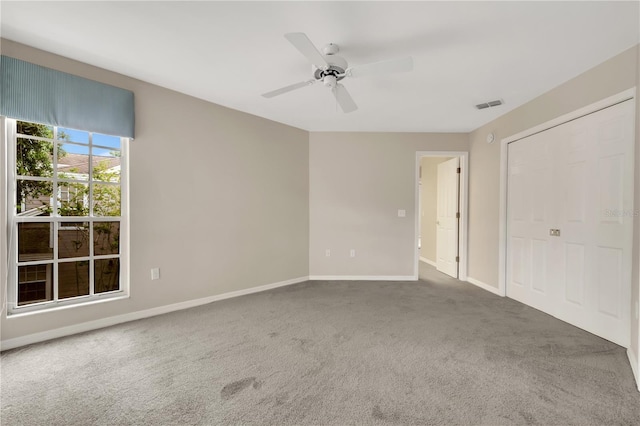 unfurnished bedroom featuring carpet floors, visible vents, baseboards, and a ceiling fan