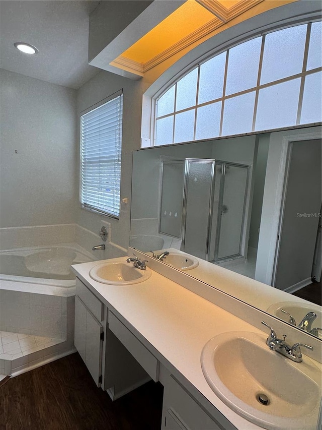 bathroom with a bath, double vanity, and a sink