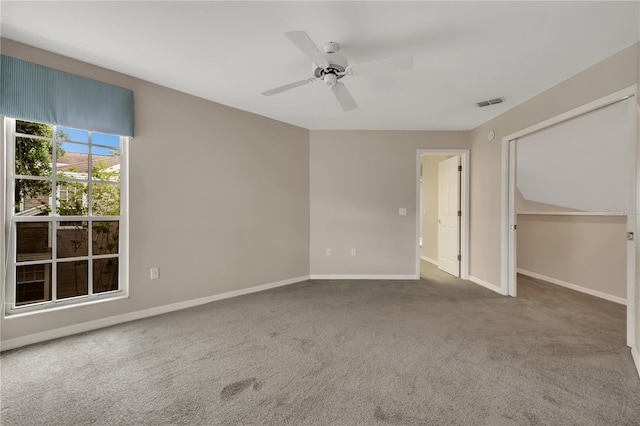 unfurnished room with carpet, visible vents, ceiling fan, and baseboards