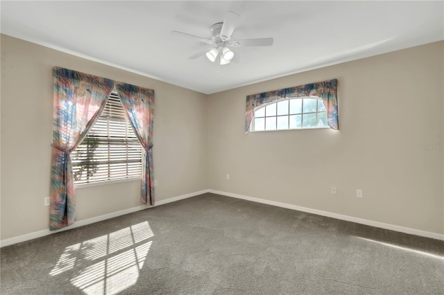 carpeted empty room with a ceiling fan and baseboards